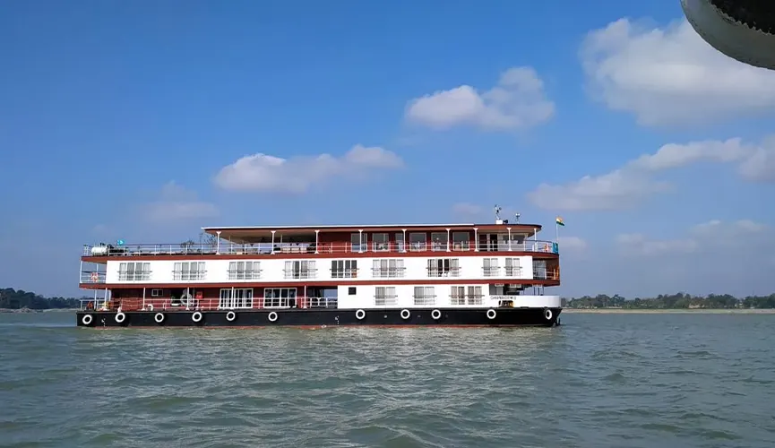 A white and black houseboat on calm waters.