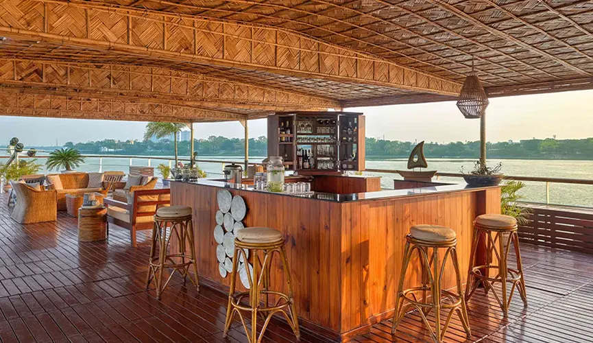 Wooden bar and seating area on a riverside deck.