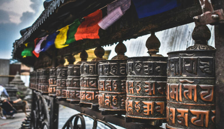 Prayer wheels with colorful flags on a temple.