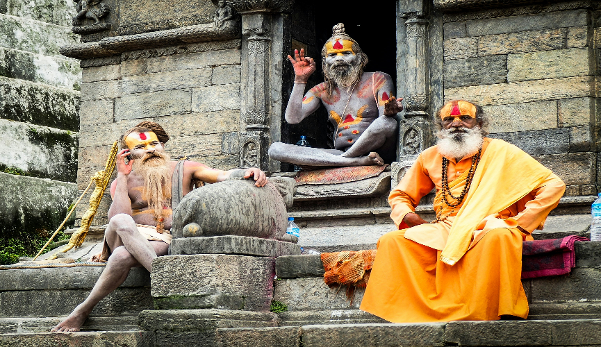 Three Hindu sages sitting on a stone platform.