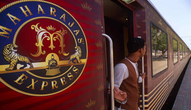 A man in formal attire near the Maharajas Express train.