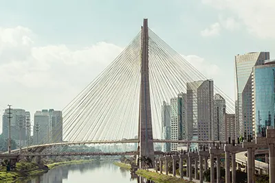 Octávio Frias de Oliveira Bridge over the Pinheiros River in São Paulo, with a city skyline.