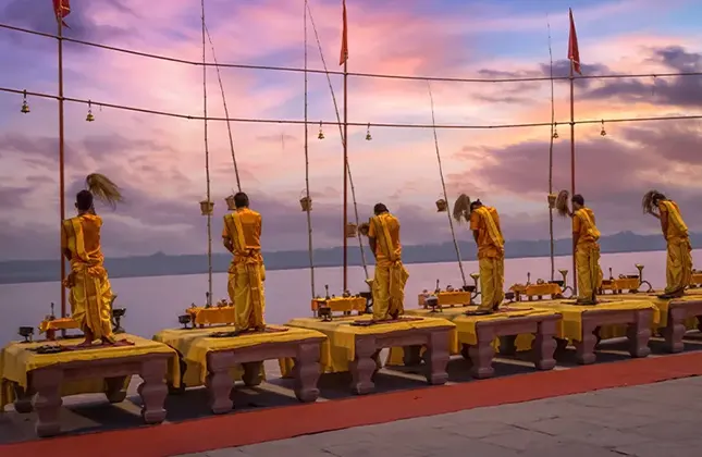 Priests performing the Ganga Aarti ritual at dusk on a ghat in Varanasi, India.