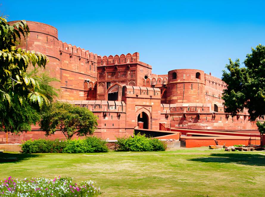 Agra Fort, a historic red sandstone fortress with lush gardens, showcasing the grandeur of Iconic Monuments in India.