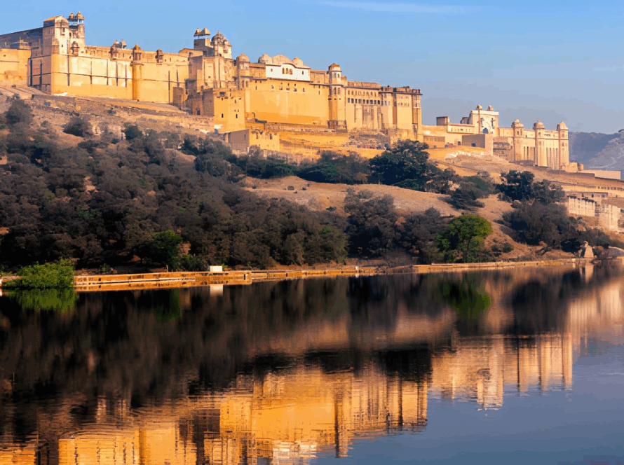 Amer Fort Jaipur: Majestic yellow sandstone palace overlooking calm river with reflection and surrounding forests