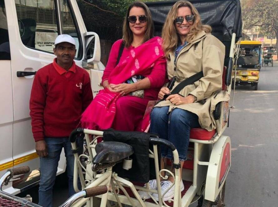 Cycle rickshaw ride in Old Delhi: Tourists enjoying traditional Indian transportation with rickshaw driver in colorful street setting