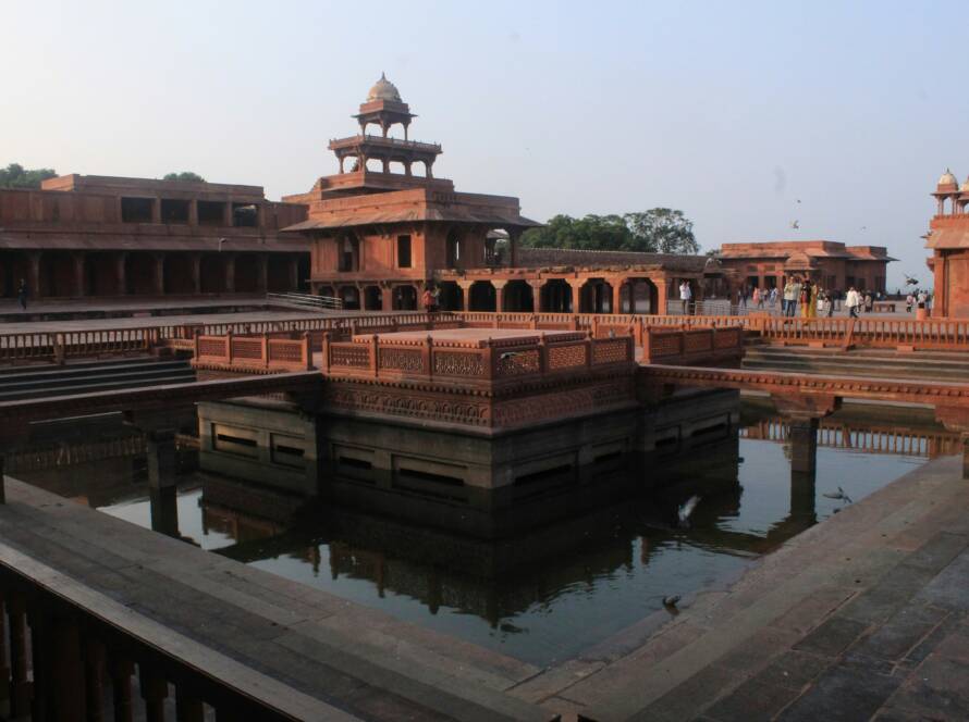 Historic red sandstone architecture and reflecting pool at Fatehpur Sikri, highlighting Iconic Monuments in India.