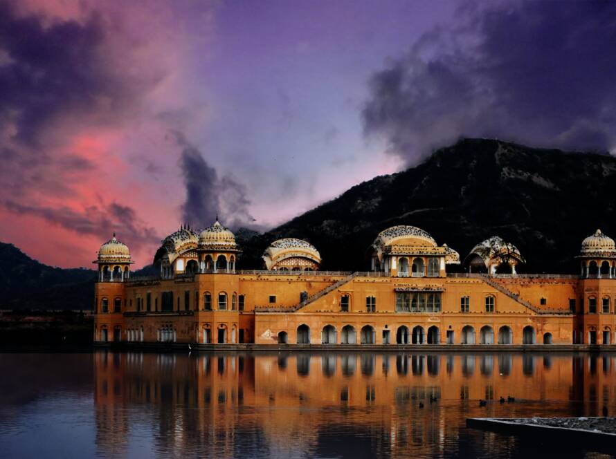 Jal Mahal palace surrounded by water at sunset in Jaipur, a stunning architectural wonder among tourist places to visit in Rajasthan.