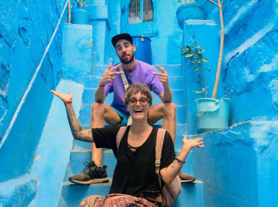 Tourists posing on the vibrant blue-painted steps in Jodhpur’s old city, a colorful highlight among tourist places to visit in Rajasthan.