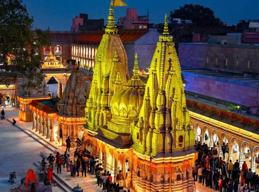 Kashi Vishwanath Temple Varanasi: Illuminated golden spires and ornate shrines crowded with devotees at night, surrounded by festive decorations