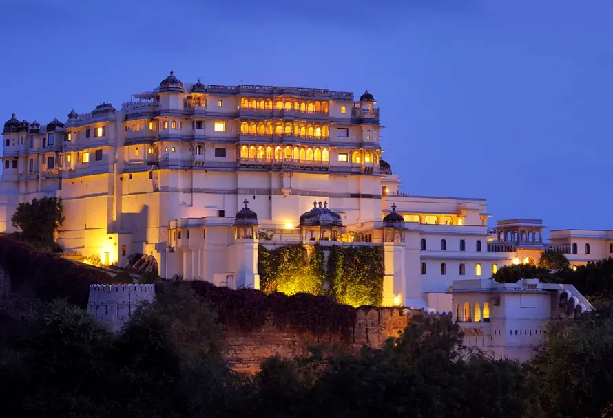 A stunning view of a palace lit up at night in Rajasthan, perfect for a Bespoke Luxury India Tour with boutique palace stays