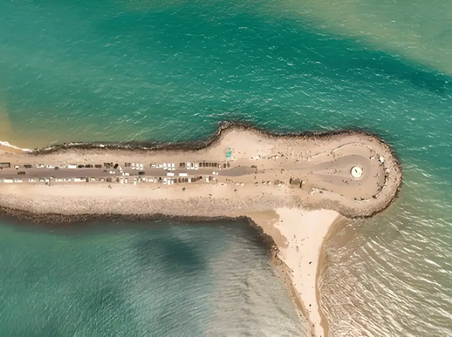 Aerial view of the thin strip of land at Dhanushkodi, Tamil Nadu, separating two shades of turquoise-blue ocean water, representing Underrated Places in India.