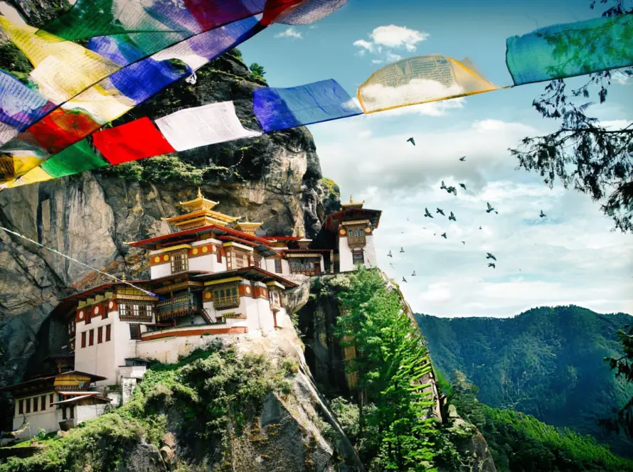 The iconic Tiger’s Nest Monastery in Paro, Bhutan, perched on a cliff amidst stunning natural scenery, a true South Asian Gem.