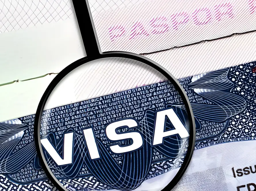 Magnifying glass over a US Visa document showing the word "VISA." blog images of tourist visa for India