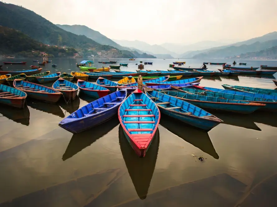 Colorful boats docked on Phewa Lake in Pokhara, Nepal, offering a serene glimpse of the natural beauty found in South Asian Gems.