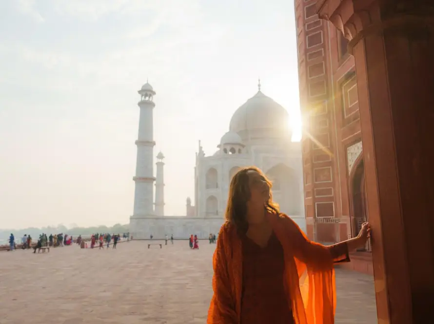 A traveler enjoying a private sunrise visit to the Taj Mahal, part of a Bespoke Luxury India Tour, with the sun casting a golden glow.