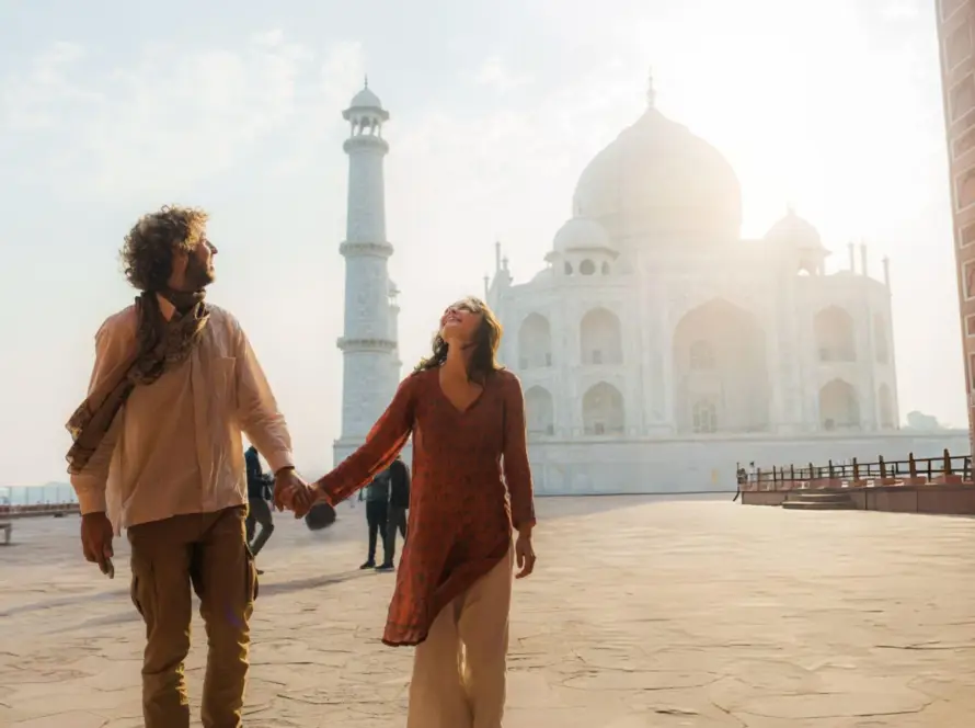 A couple walking hand-in-hand near the Taj Mahal, Agra, India, capturing the timeless beauty of one of the most iconic South Asian Gems.