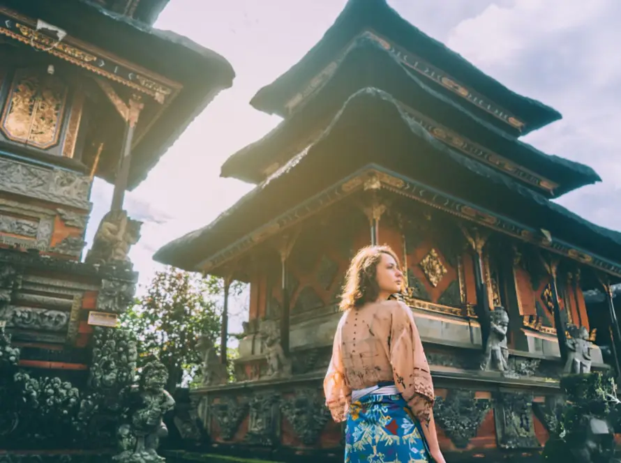 A traveler exploring the intricate architecture of a temple in Ubud, Bali, capturing the cultural beauty of South Asian Gems